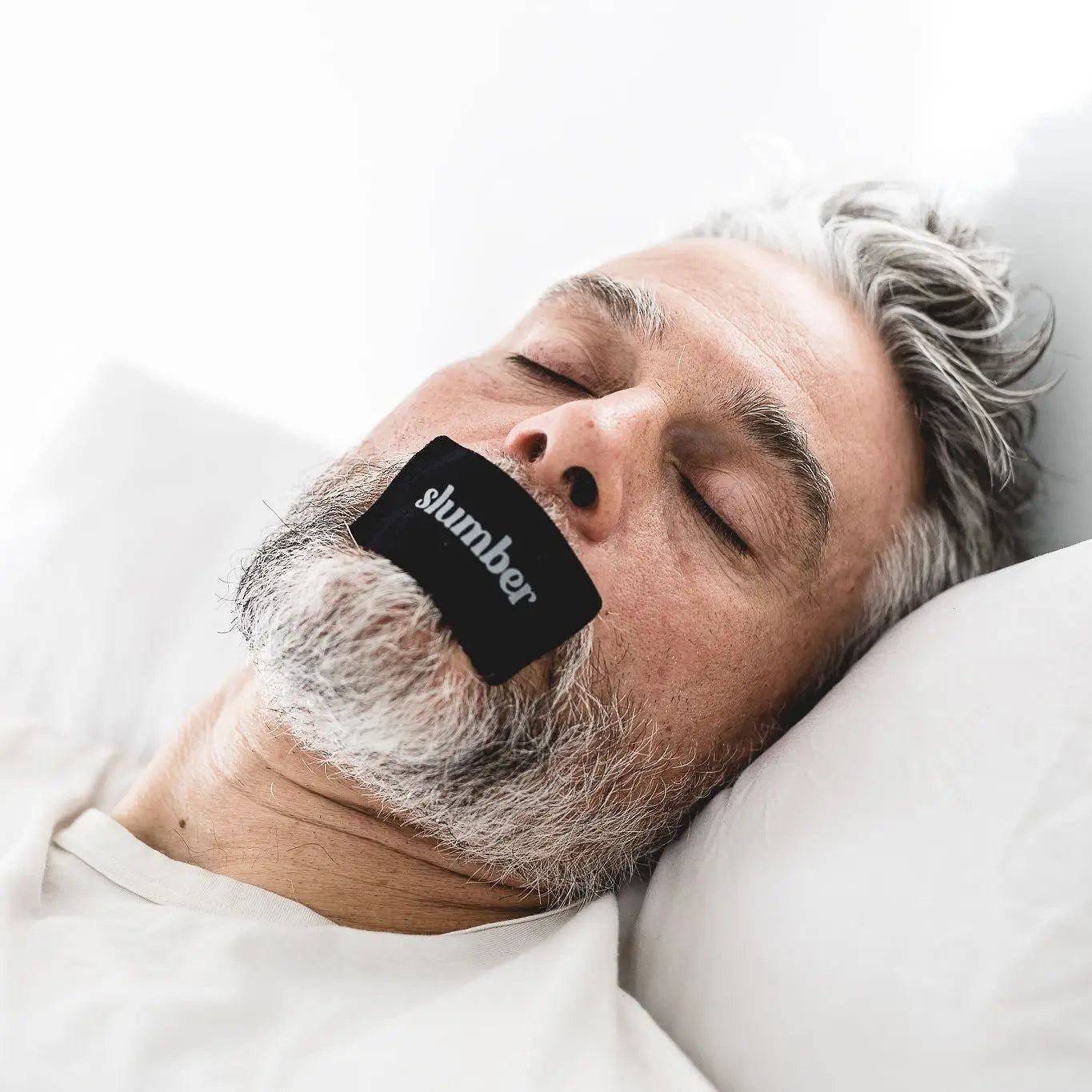 Man sleeping peacefully with Slumber mouth tape, promoting nasal breathing and restful sleep."
