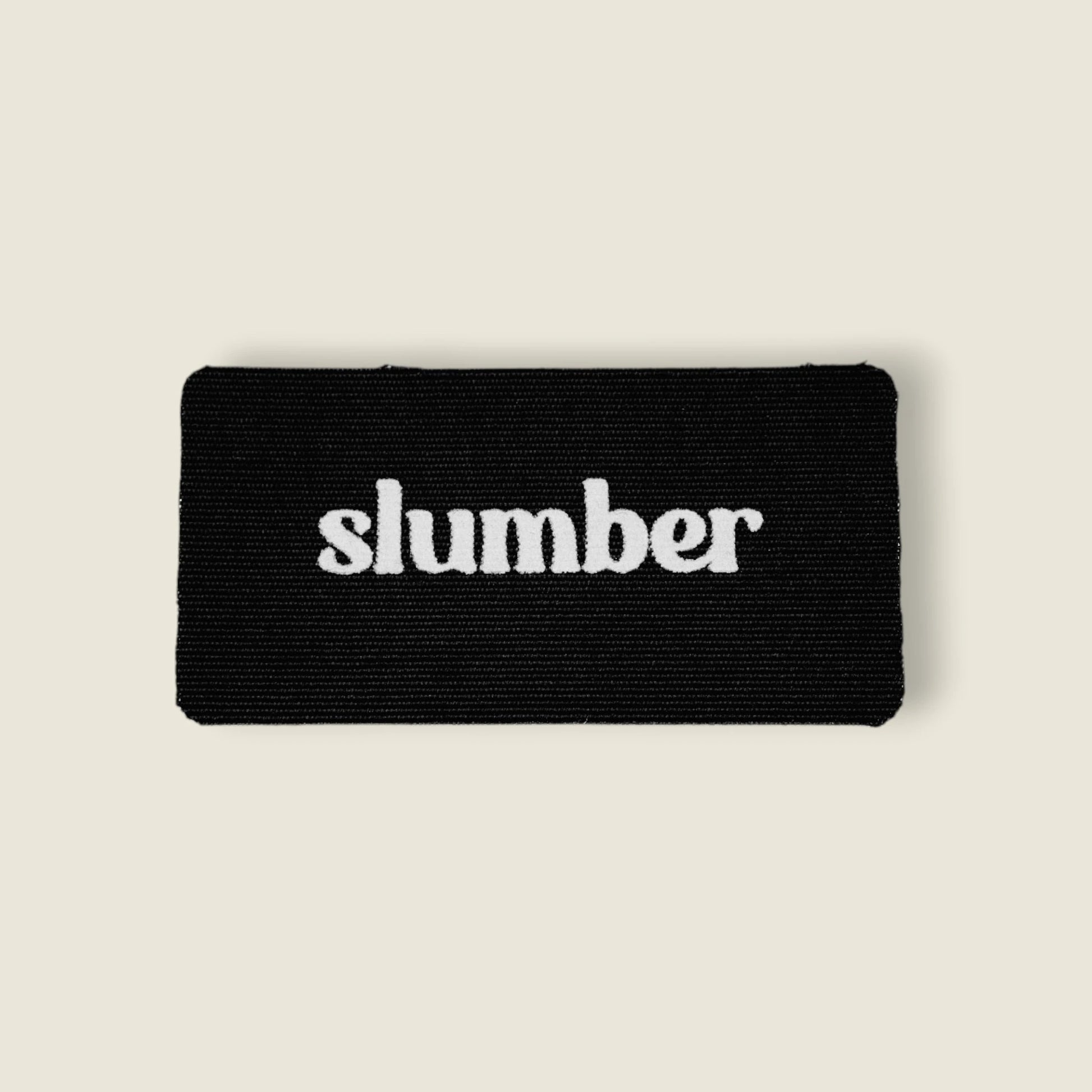 Close-up of Slumber black mouth tape with white logo, designed for better sleep and nasal breathing.