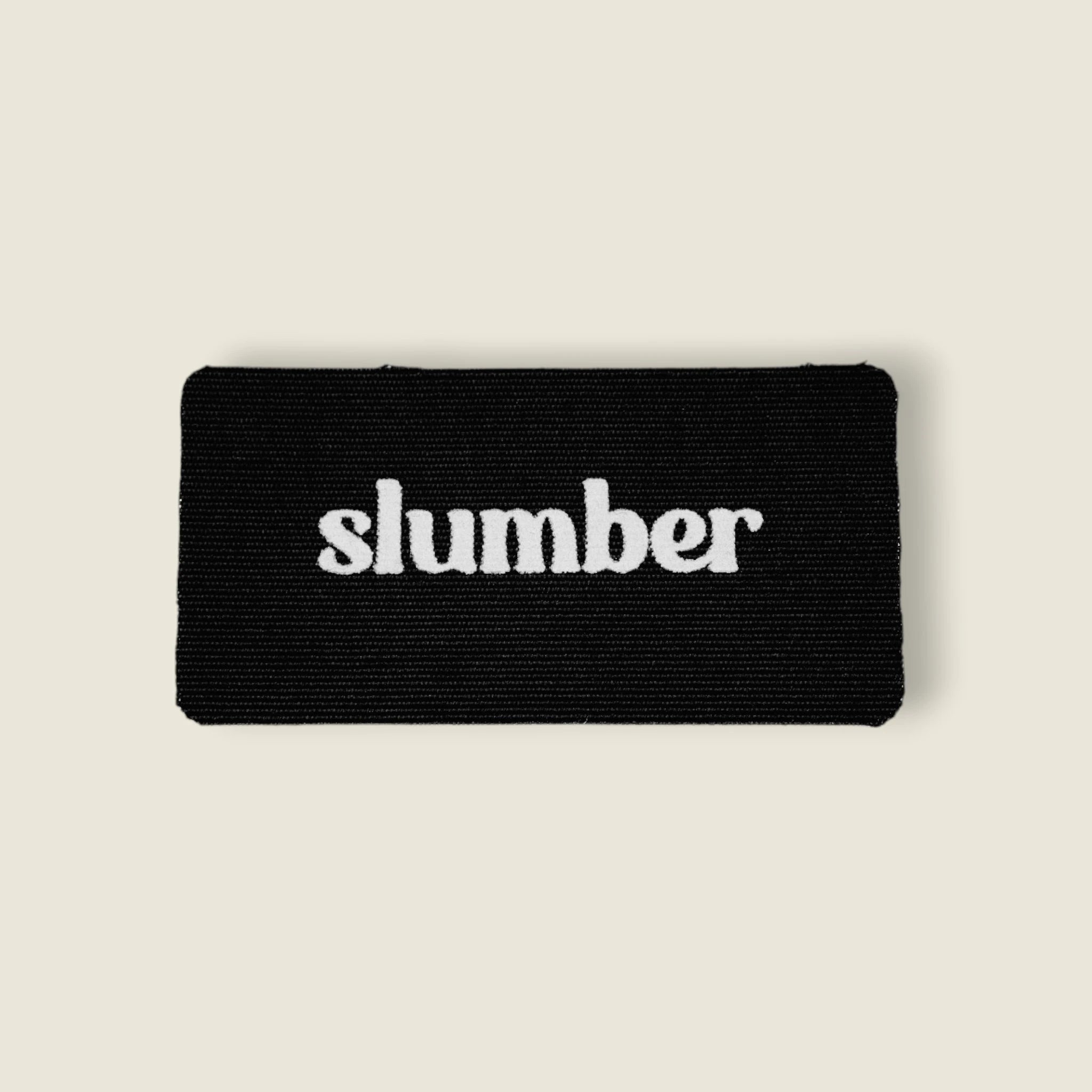 Close-up of Slumber black mouth tape with white logo, designed for better sleep and nasal breathing.
